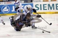 Voller Einsatz von Wyatt Smith (blau) im Zweikampf mit (Rene Kramer). Sogar im Flug kämpft Smith um die Scheibe. Aufgenommen im Spiel zwischen ERC Ingolstadt und EHC München in der Ingolstädter Saturn Arena am 20.02.2011. Endstand 2:3 nach Penaltyschiesse