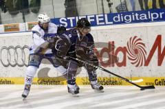 Tim Hambly (blau) im Zweikampf um den Puck gegen Mike Kompon (weiss). Aufgenommen im Spiel zwischen ERC Ingolstadt und EHC München in der Ingolstädter Saturn Arena am 20.02.2011. Endstand 2:3 nach Penaltyschiessen.