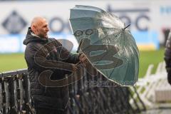 3. Liga - Hansa Rostock - FC Ingolstadt 04 - Im Interview Geschäftsführer Manuel Sternisa (FCI) kämpf mit Wind Wetter Sturm Regen Regenschirm