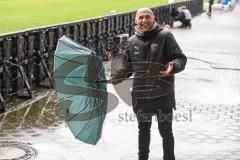 3. Liga - Hansa Rostock - FC Ingolstadt 04 - Im Interview Geschäftsführer Manuel Sternisa (FCI) kämpf mit Wind Wetter Sturm Regen Regenschirm