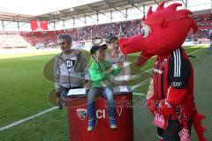 1. Bundesliga - Fußball - FC Ingolstadt 04 - SV Darmstadt 98 - Stadionsprecher Italo Mele und Silke von Walkhoff mit dem Siegerkind bei der Stadionführung, Schanzi ist mit dabei