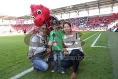 1. Bundesliga - Fußball - FC Ingolstadt 04 - SV Darmstadt 98 - Stadionsprecher Italo Mele und Silke von Walkhoff mit dem Siegerkind bei der Stadionführung, Schanzi ist mit dabei