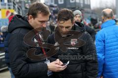 2. Bundesliga - Fußball - Holstein Kiel - FC Ingolstadt 04 - Pressesprecher Oliver Samwald (FCI) und Cheftrainer Stefan Leitl (FCI) checken die Ergebnisse der anderen Mannschaften