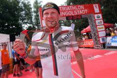 Triathlon Ingolstadt 2015 - Baggersee - Olympische Distanz, Ziel Einlauf, Emotion, Sieger Per Bittner (Leipzig) Jubel, zeigt die Medaille