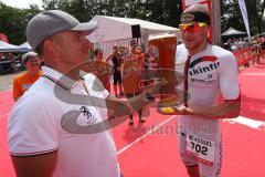 Triathlon Ingolstadt 2015 - Baggersee - Olympische Distanz, Ziel Einlauf, Emotion, Sieger Per Bittner (Leipzig) Jubel, Organisator überreicht das Bierglas