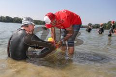 Triathlon Ingolstadt 2019 - Olympische Distanz, Max Schwarzhuber startet mit amputierten Unterschenkeln, Gerhard Budy hilft bei Anbringung der Schwimmhilfe an den Prothesen