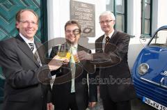 Audi Enthüllung Bronzetafel - Vor 60 Jahren wurde die Auto Union GmbH in Ingolstadt gegründet. Links Thomas Frank, Leiter Audi Tradition, Peter Mosch Gesamtbetriebsratsvorsitzender und rechts Personlavorstand Dr. Werner Widuckel stoßen mit Libelle Limonad